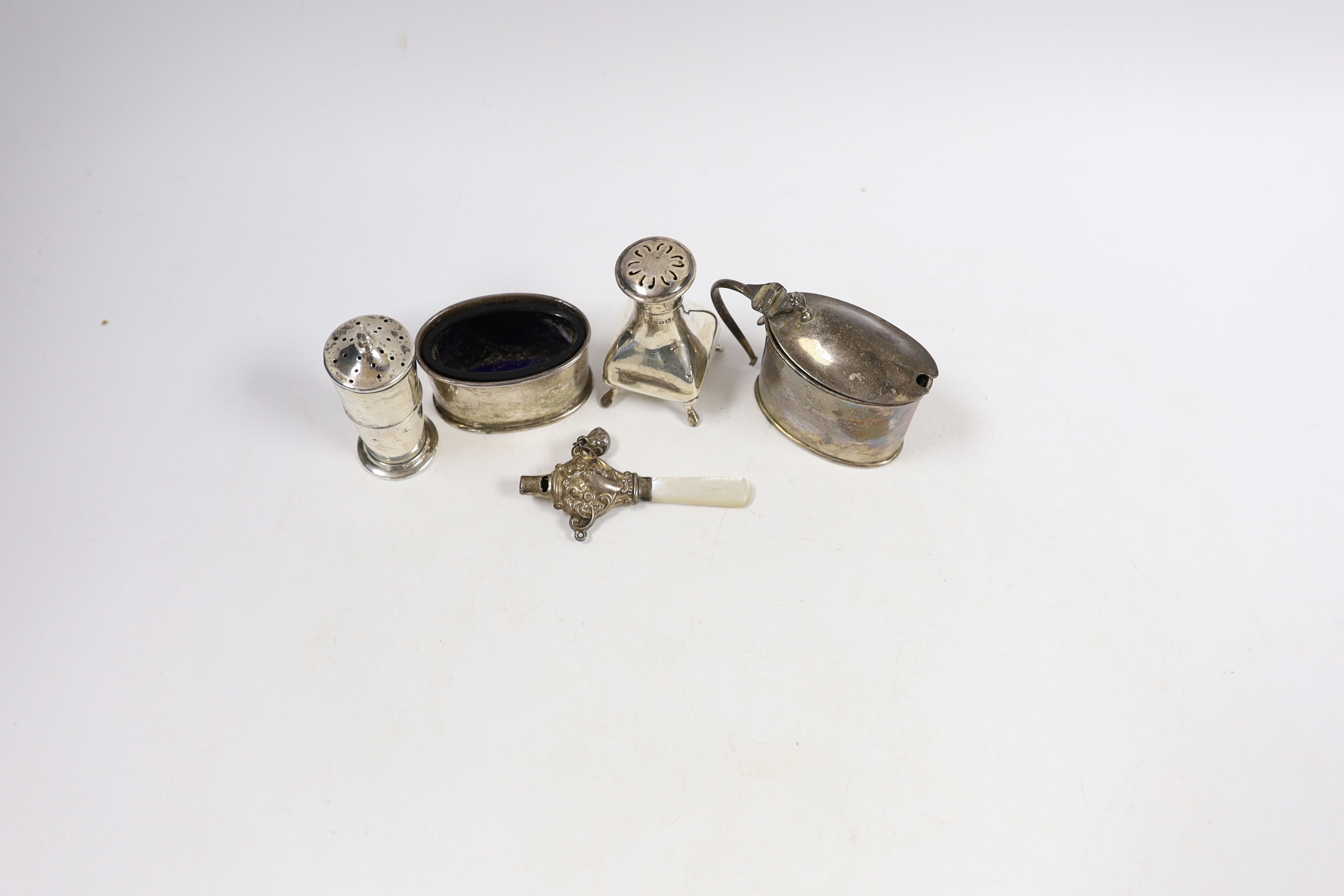 Four assorted silver cruets and a silver child's rattle.